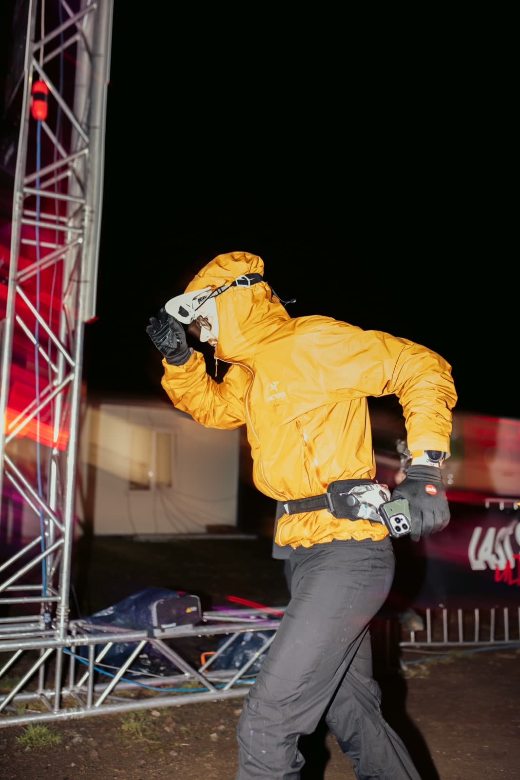 Pierre Biege nachts beim Last Soul Ultra, orange Jacke und Stirnlampe