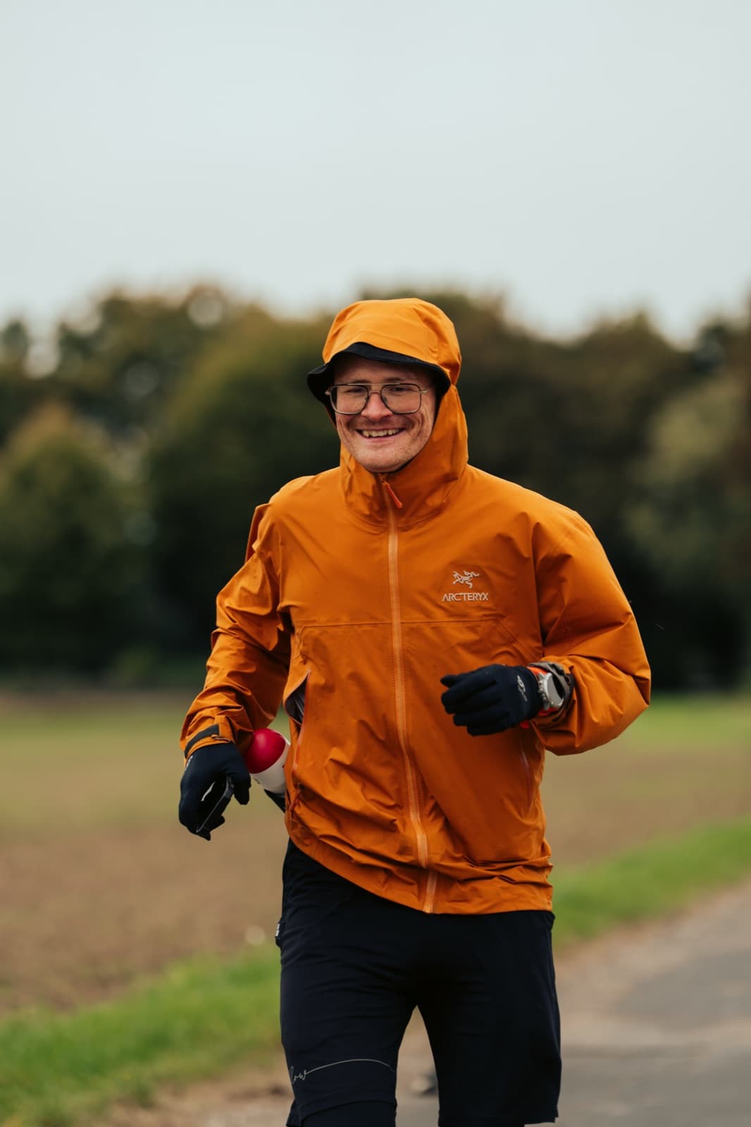 Pierre Biege lächelnd unterwegs in orange Jacke